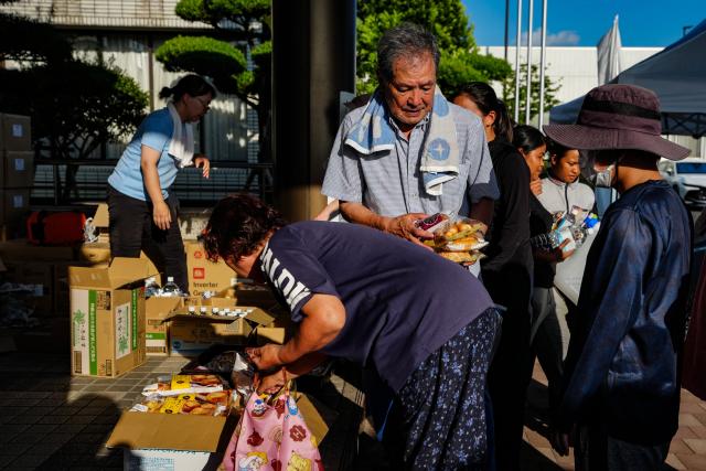 (260731) -- KUMAMOTO, July 31, 2026 (Xinhua) -- People receive relief materials at a shelter in Kumamoto Prefecture, Japan, July 30, 2026. The death toll from a powerful earthquake that struck Japan's Kumamoto Prefecture has risen to 35, the prefectural government said Friday. (Xinhua/Jia Haocheng)