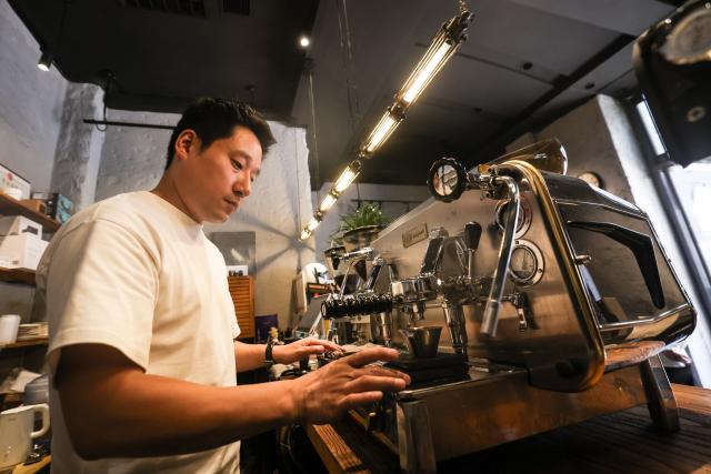 (260802) -- SHENYANG, Aug. 2, 2026 (Xinhua) -- A barista brews coffee at a coffee shop on Bajing Street, Shenyang City, northeast China's Liaoning Province, Aug. 1, 2026. A pack of coffee shops of varying styles on Bajing Street in Shenyang have breathed new life into the old city. Once quiet but obsolete, this historic street is now a vibrant new landmark of culture and tourism that attracts thousands of young visitors every day. Each coffee shop here tells a different story of how a city grows in time. (Xinhua/Pan Yulong)