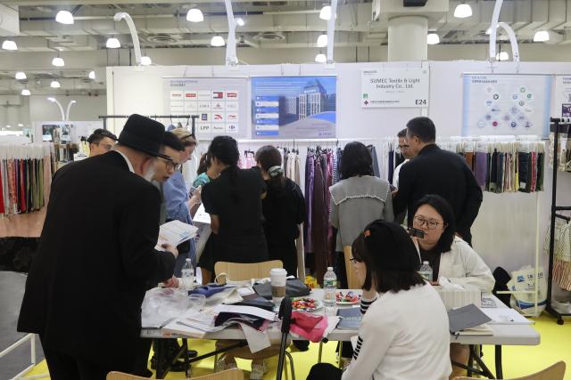 (260802) -- NEW YORK, Aug. 2, 2026 (Xinhua) -- Visitors check textile samples at Texworld NYC, a textile sourcing trade show, in New York City, the United States, July 30, 2026. TO GO WITH "Economic Watch: Exhibitors at U.S. textile trade show grapple with unprecedented headwinds" (Photo by Li Xirui/Xinhua)
