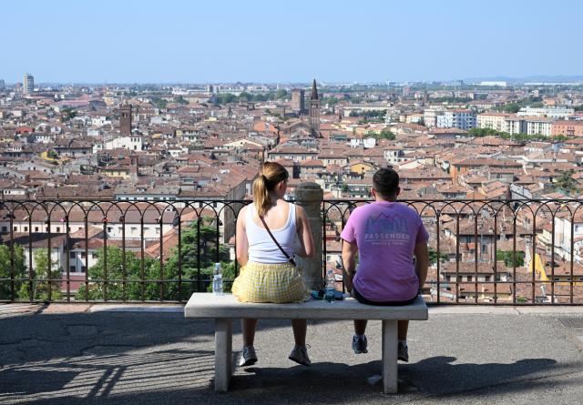 (260802) -- VERONA, Aug. 2, 2026 (Xinhua) -- Tourists sit to watch the panorama view of the city in Verona, Italy, Aug. 2, 2026. (Photo by Alberto Lingria/Xinhua)