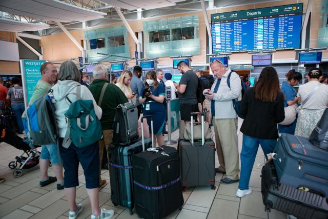 (260802) -- VANCOUVER, Aug. 2, 2026 (Xinhua) -- Travelers wait at the check-in counters after WestJet flights were cancelled at Vancouver International Airport in Richmond, British Columbia, Canada, on Aug. 2, 2026. Canada's second-largest airline, WestJet, was hit by a flight attendants' strike on Sunday, triggering hundreds of flight cancellations during one of the busiest travel weekends of the summer. (Photo by Liang Sen/Xinhua)