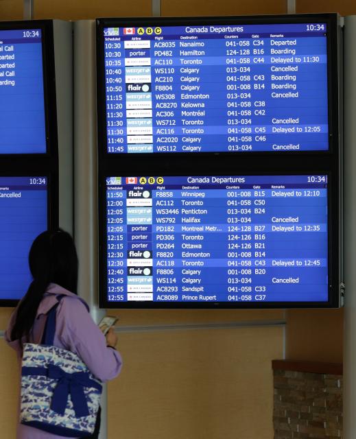 (260802) -- VANCOUVER, Aug. 2, 2026 (Xinhua) -- A traveler looks to an information board as WestJet flights are cancelled at Vancouver International Airport in Richmond, British Columbia, Canada, on Aug. 2, 2026. Canada's second-largest airline, WestJet, was hit by a flight attendants' strike on Sunday, triggering hundreds of flight cancellations during one of the busiest travel weekends of the summer. (Photo by Liang Sen/Xinhua)