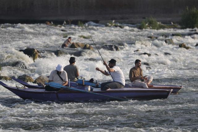 (260802) -- CAIRO, Aug. 2, 2026 (Xinhua) -- People fish at a riffle on the Nile River to escape the heat of summer in Qalyubia Governorate, Egypt, on August 2, 2026. (Photo by Ahmed Gomaa/Xinhua)