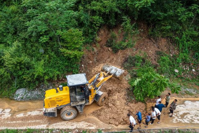 (260803) -- BEIJING, Aug. 3, 2026 (Xinhua) -- A drone photo taken on Aug. 1, 2026 shows people clearing a road blocked by a mudslide in Fanjiaping Village of Yuhe Town in Longnan, northwest China's Gansu Province. Longnan in northwest China's Gansu Province has activated Level II emergency response for flood control due to widespread heavy rainfall since Wednesday. Authorities at different levels have carried out inspections and assessments for potential hazards and repairs of damaged infrastructure, so as to safeguard people's lives and property. (Xinhua/Lang Bingbing)
