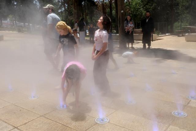 (260803) -- JERUSALEM, Aug. 3, 2026 (Xinhua) -- People cool off during a heatwave at a park in Jerusalem, Aug. 2, 2026. A severe heatwave has swept across Jerusalem in recent days. (Photo by Gil Cohen Magen/Xinhua)
