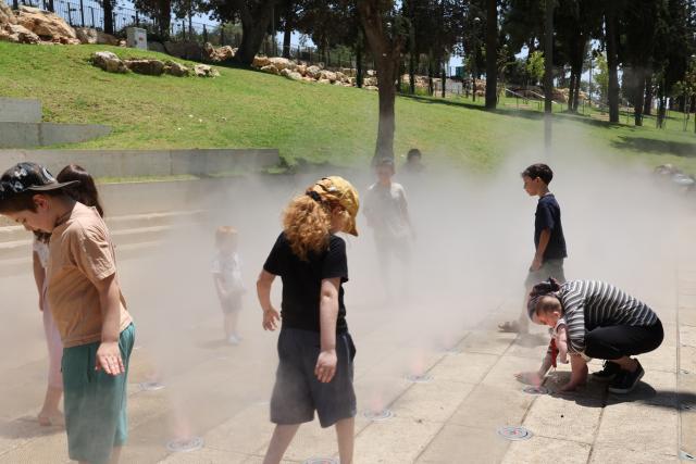 (260803) -- JERUSALEM, Aug. 3, 2026 (Xinhua) -- People cool off during a heatwave at a park in Jerusalem, Aug. 2, 2026. A severe heatwave has swept across Jerusalem in recent days. (Photo by Gil Cohen Magen/Xinhua)