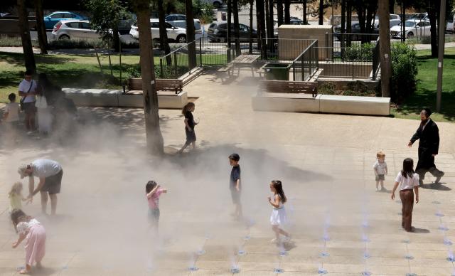 (260803) -- JERUSALEM, Aug. 3, 2026 (Xinhua) -- People cool off during a heatwave at a park in Jerusalem, Aug. 2, 2026. A severe heatwave has swept across Jerusalem in recent days. (Photo by Gil Cohen Magen/Xinhua)