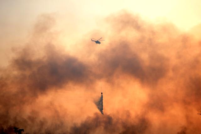 (260803) -- SOUTH SUMATRA, Aug. 3, 2026 (Xinhua) -- This photo taken on Aug. 2, 2026 shows a helicopter dumping water to extinguish a peatland fire in Ogan Ilir regency, South Sumatra province, Indonesia. Indonesia recorded more than 5,000 wildfire hotspots as of mid-July 2026, with the cumulative increase outpacing previous El Nino years, the Meteorology, Climatology and Geophysics Agency said Thursday. (Photo by Muhamad Fadjri/Xinhua)