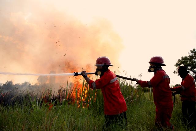 (260803) -- SOUTH SUMATRA, Aug. 3, 2026 (Xinhua) -- This photo taken on Aug. 2, 2026 shows firefighters trying to extinguish a peatland fire in Ogan Ilir regency, South Sumatra province, Indonesia. Indonesia recorded more than 5,000 wildfire hotspots as of mid-July 2026, with the cumulative increase outpacing previous El Nino years, the Meteorology, Climatology and Geophysics Agency said Thursday. (Photo by Muhamad Fadjri/Xinhua)