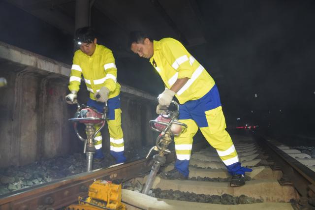 (260803) -- VIENTIANE, Aug. 3, 2026 (Xinhua) -- Chinese mentor Li Li (R) and his Lao apprentice Bounyadeth Thepvongsa do track maintenance work at Meuangxay Station of the China-Laos Railway in Meuangxay, Laos, July 30, 2026. TO GO WITH "Feature: From protecting homelands to safeguarding railway -- Retired veterans, apprentices on China-Laos Railway" (Photo by Pu Hongsi/Xinhua)