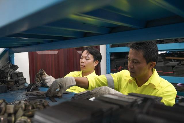 (260803) -- VIENTIANE, Aug. 3, 2026 (Xinhua) -- Chinese mentor Li Li (R) arranges tools with his Lao apprentice Bounyadeth Thepvongsa at the Meuangxay Comprehensive Maintenance Workshop of the China-Laos Railway in Meuangxay, Laos, July 30, 2026. TO GO WITH "Feature: From protecting homelands to safeguarding railway -- Retired veterans, apprentices on China-Laos Railway" (Photo by Pu Hongsi/Xinhua)