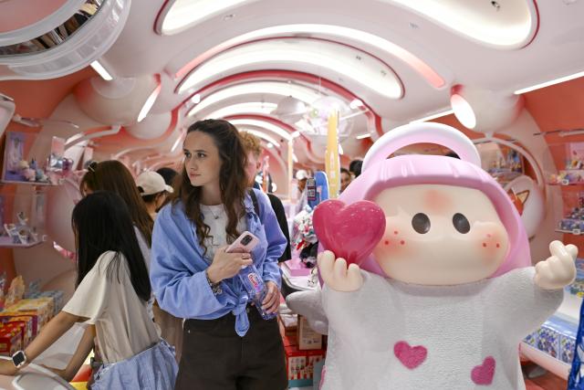 (260803) -- HANGZHOU, Aug. 3, 2026 (Xinhua) -- A foreign tourist visits a trendy toy store in Shanghai, east China, May 5, 2026. (Xinhua/Chen Haoming)