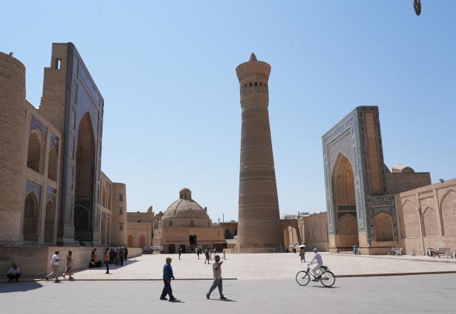 (260803) -- BUKHARA, Aug. 3, 2026 (Xinhua) -- People walk across the Po-i-Kalyan Complex in Bukhara, Uzbekistan, Aug. 3, 2026. The historic city of Bukhara in southwestern Uzbekistan is currently gripping with severe heat, with daytime highs consecutively exceeding 35 degrees Celsius. (Photo by Zafar Khalilov/Xinhua)