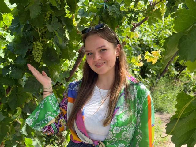 (260804) -- YINCHUAN, Aug. 4, 2026 (Xinhua) -- Russian student Vayner Valeriya poses for a photo at a vineyard in Shizuishan, northwest China's Ningxia Hui Autonomous Region, on July 14, 2026. TO GO WITH "Across China: From barren land, a wine region takes root" (Xinhua/Xie Jianwen)