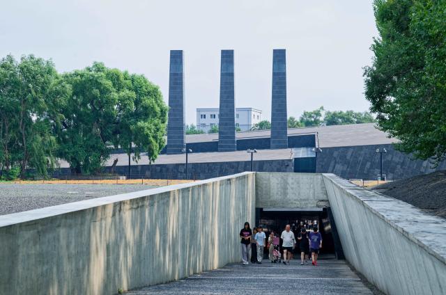 (260804) -- HARBIN, Aug. 4, 2026 (Xinhua) -- People walk out of the Exhibition Hall of Evidences of Crime Committed by Unit 731 of the Japanese Imperial Army in Pingfang District of Harbin, northeast China's Heilongjiang Province, Aug. 4, 2026. During the summer vacation, the Exhibition Hall of Evidences of Crime Committed by Unit 731 of the Japanese Imperial Army has greeted lots of visitors. 
   People tour the exhibition hall to view archival evidence exposing the germ warfare crimes perpetrated by notorious Japanese Unit 731 during World War II. 
   Unit 731 was a top-secret biological and chemical warfare research base established as the nerve center for Japanese biological warfare in China and Southeast Asia during WWII. At least 3,000 people were used in human experiments conducted by Unit 731, and more than 300,000 people in China were killed by Japan's biological weapons. (Xinhua/Zhang Tao)