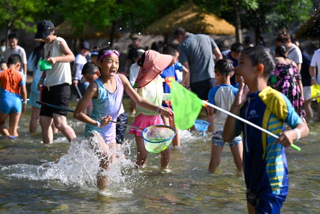 (260804) -- TIANJIN, Aug. 4, 2026 (Xinhua) -- Tourists play at a water park in Tianjin, north China, Aug. 4, 2026. (Xinhua/Sun Fanyue)