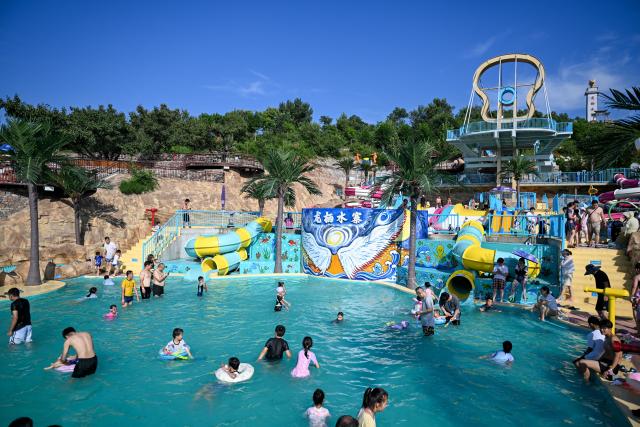 (260804) -- TIANJIN, Aug. 4, 2026 (Xinhua) -- Tourists play at a water park in Tianjin, north China, Aug. 4, 2026. (Xinhua/Sun Fanyue)