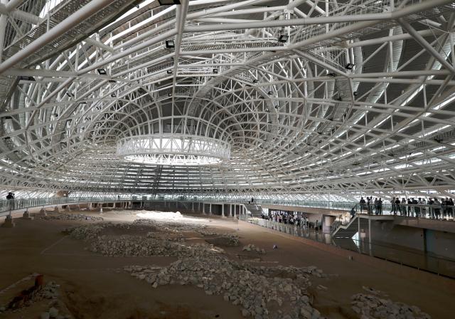 (260804) -- CHAOYANG, Aug. 4, 2026 (Xinhua) -- People visit an exhibition hall within the Niuheliang national archaeological relic site park in Chaoyang City, northeast China's Liaoning Province, Aug. 4, 2026. The Niuheliang national archaeological relic site park was built on the Niuheliang site, a large-scale prehistoric ritual and burial complex featuring the temple of the goddess, altars and stone tombs. Dating back more than 5,000 years, the site unearthed stone tools, pottery and jade artifacts with dragon, phoenix and human motifs, reflecting the rituals and beliefs of the Hongshan culture. (Xinhua/Li Gang)