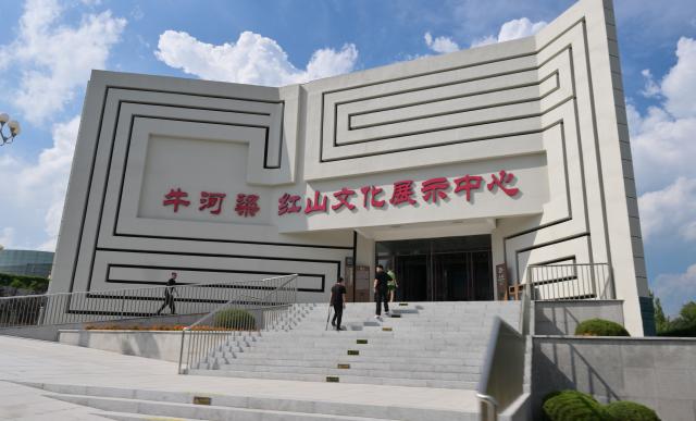 (260804) -- CHAOYANG, Aug. 4, 2026 (Xinhua) -- People visit an exhibition center for Hongshan Culture at the Niuheliang national archaeological relic site park in Chaoyang City, northeast China's Liaoning Province, Aug. 4, 2026. The Niuheliang national archaeological relic site park was built on the Niuheliang site, a large-scale prehistoric ritual and burial complex featuring the temple of the goddess, altars and stone tombs. Dating back more than 5,000 years, the site unearthed stone tools, pottery and jade artifacts with dragon, phoenix and human motifs, reflecting the rituals and beliefs of the Hongshan culture. (Xinhua/Li He)
