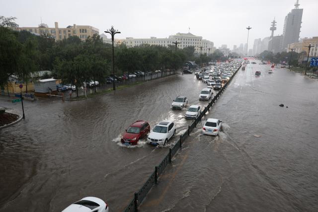(260804) -- HARBIN, Aug. 4, 2026 (Xinhua) -- Vehicles move on a waterlogged street in Harbin, northeast China's Heilongjiang Province, Aug. 4, 2026. A heavy rain swept the city of Harbin on Tuesday. (Xinhua/Wang Song)