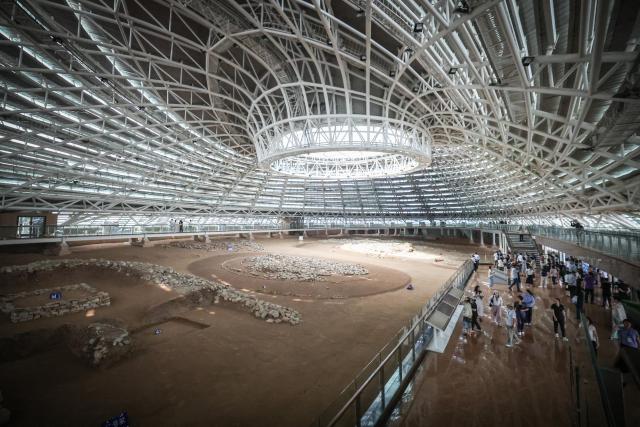 (260804) -- CHAOYANG, Aug. 4, 2026 (Xinhua) -- People visit an exhibition hall within the Niuheliang national archaeological relic site park in Chaoyang City, northeast China's Liaoning Province, Aug. 4, 2026. The Niuheliang national archaeological relic site park was built on the Niuheliang site, a large-scale prehistoric ritual and burial complex featuring the temple of the goddess, altars and stone tombs. Dating back more than 5,000 years, the site unearthed stone tools, pottery and jade artifacts with dragon, phoenix and human motifs, reflecting the rituals and beliefs of the Hongshan culture. (Xinhua/Pan Yulong)