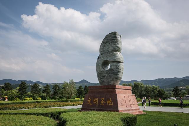 (260804) -- CHAOYANG, Aug. 4, 2026 (Xinhua) -- People visit the Niuheliang national archaeological relic site park in Chaoyang City, northeast China's Liaoning Province, Aug. 4, 2026. The Niuheliang national archaeological relic site park was built on the Niuheliang site, a large-scale prehistoric ritual and burial complex featuring the temple of the goddess, altars and stone tombs. Dating back more than 5,000 years, the site unearthed stone tools, pottery and jade artifacts with dragon, phoenix and human motifs, reflecting the rituals and beliefs of the Hongshan culture. (Xinhua/Pan Yulong)