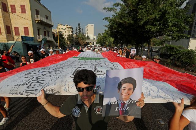 (260804) -- BEIRUT, Aug. 4, 2026 (Xinhua) -- People hold a national flag and portraits of the victims in commemoration of the sixth anniversary of the 2020 Beirut port blasts in Beirut, Lebanon, Aug. 4, 2026. (Xinhua/Bilal Jawich)