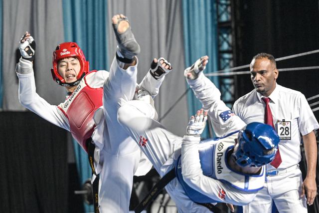 (260805) -- JAKARTA, Aug. 5, 2026 (Xinhua) -- Wai Fung Lo (L) of China's Hong Kong competes with Matthew Summerfield of Australia during the men's Kyorugi -68kg final match of Taekwondo at the 8th Asian Taekwondo Indonesia Open Championships 2026 in Jakarta, Indonesia, Aug. 4, 2026. (Xinhua/Agung Kuncahya B.)