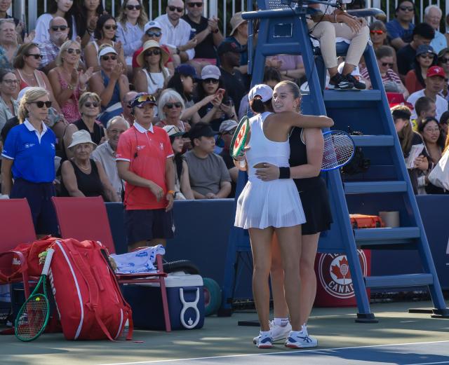(260805) -- TORONTO, Aug. 5, 2026 (Xinhua) -- Zhang Shuai (front) of China and Jelena Ostapenko of Latvia hug each other after their second round of the women's singles match at the 2026 National Bank Open tennis tournament in Toronto, Canada, on Aug. 4, 2026. (Photo by Zou Zheng/Xinhua)