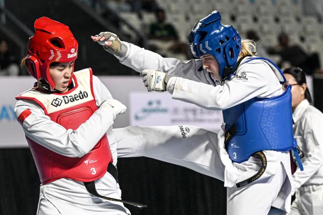 (260805) -- JAKARTA, Aug. 5, 2026 (Xinhua) -- Grabriella Blewitt (R) of Australia competes with Ingrid Poetri Iskandar of Singapore during the women's Kyorugi -62kg final match of Taekwondo at the 8th Asian Taekwondo Indonesia Open Championships 2026 in Jakarta, Indonesia, Aug. 4, 2026. (Xinhua/Agung Kuncahya B.)