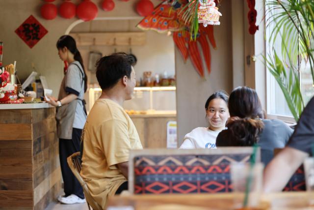 (260805) -- TIANJIN, Aug. 5, 2026 (Xinhua) -- Visitors rest at a cafe in Xijingyu Village, Jizhou District of north China's Tianjin Municipality, Aug. 4, 2026. During summer vacation, Xijingyu Village has attracted lots of visitors. Known as the "Stone Village", it is famous for its distinctive houses and alleys built of stones. (Xinhua/Li Ran)
