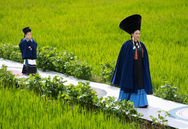 (260805) -- YUEXI, Aug. 5, 2026 (Xinhua) -- Models dressed in traditional ethnic costumes walk amid a rice field during a fashion show at Qietuo Village in Yuexi County of Liangshan Yi Autonomous Prefecture, southwest China's Sichuan Province, on Aug. 4, 2026. Sixty models from across the Liangshan Yi Autonomous Prefecture on Tuesday showcased traditional ethnic costumes and fashion creations here. (Xinhua/Jiang Hongjing)