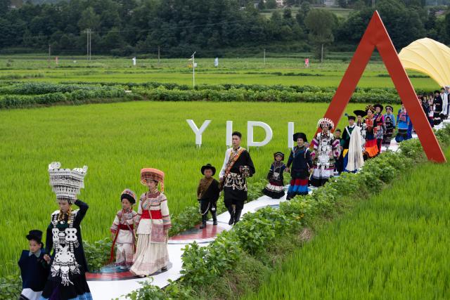 (260805) -- YUEXI, Aug. 5, 2026 (Xinhua) -- Models dressed in traditional ethnic costumes walk amid a rice field during a fashion show at Qietuo Village in Yuexi County of Liangshan Yi Autonomous Prefecture, southwest China's Sichuan Province, on Aug. 4, 2026. Sixty models from across the Liangshan Yi Autonomous Prefecture on Tuesday showcased traditional ethnic costumes and fashion creations here. (Xinhua/Jiang Hongjing)