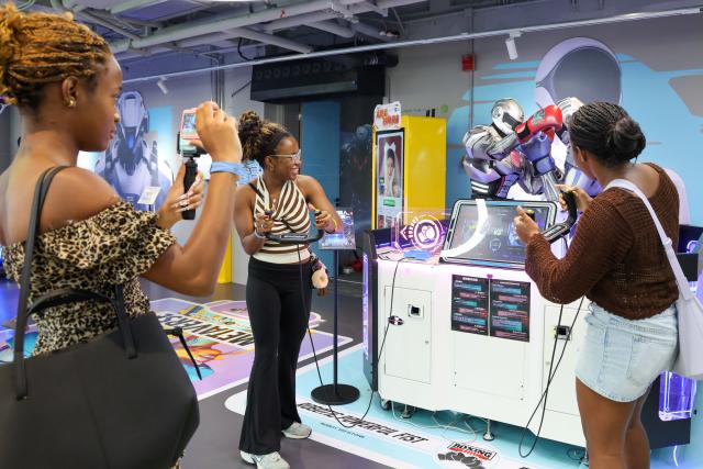 (260805) -- SHENZHEN, Aug. 5, 2026 (Xinhua) -- Tourists from Jamaica play an interactive game at a robot shop in Longgang District of Shenzhen, south China's Guangdong Province, Aug. 4, 2026. With the deep application of the achievements of emerging industries, many inbound foreign tourists choose science and technology tour as the theme of their journey in the Chinese cities. 
  In Shenzhen, foreign tourists are attracted by AI applications and technology scenarios in daily life, such as AI glasses, smart robots and unmanned delivery service. (Xinhua/Liang Xu)