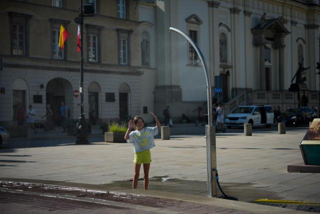 (260805) -- WARSAW, Aug. 5, 2026 (Xinhua) -- A girl cools off under a mist-cooling device amid a heatwave in Warsaw, Poland, Aug. 4, 2026. (Photo by Jaap Arriens/Xinhua)