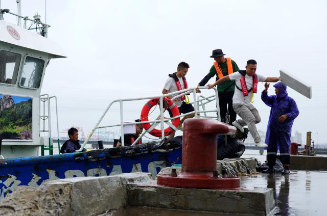 (260805) -- HANGZHOU, Aug. 5, 2026 (Xinhua) -- People on a leisure cruise return to a port in Wenzhou, east China's Zhejiang Province, Aug. 5, 2026.
  As Typhoon Dolphin, the 13th typhoon of 2026, is approaching the East China Sea, Zhejiang activated an emergency response along its coastal areas from 6 p.m. Wednesday. (Photo by Cai Kuanyuan/Xinhua)