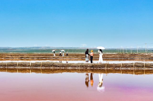 (260805) -- ORDOS, Aug. 5, 2026 (Xinhua) -- A drone photo taken on Aug. 5, 2026 shows tourists having fun at a salt lake in Otog Front Banner in the city of Ordos, north China's Inner Mongolia Autonomous Region. (Photo by Wang Zheng/Xinhua)