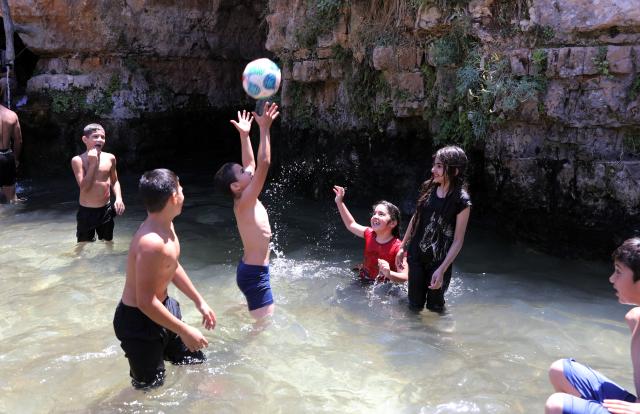 (260805) -- BETHLEHEM, Aug. 5, 2026 (Xinhua) -- Palestinian teenagers cool off at a pond during hot summer day in the village of Battir, west of the West Bank city of Bethlehem on Aug. 5, 2026. (Photo by Mamoun Wazwaz/Xinhua)