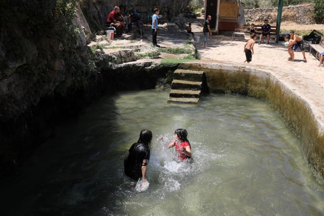 (260805) -- BETHLEHEM, Aug. 5, 2026 (Xinhua) -- Palestinian teenagers cool off at a pond during hot summer day in the village of Battir, west of the West Bank city of Bethlehem on Aug. 5, 2026. (Photo by Mamoun Wazwaz/Xinhua)