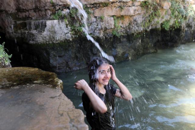 (260805) -- BETHLEHEM, Aug. 5, 2026 (Xinhua) -- A palestinian girl cools off at a pond during hot summer day in the village of Battir, west of the West Bank city of Bethlehem on Aug. 5, 2026. (Photo by Mamoun Wazwaz/Xinhua)