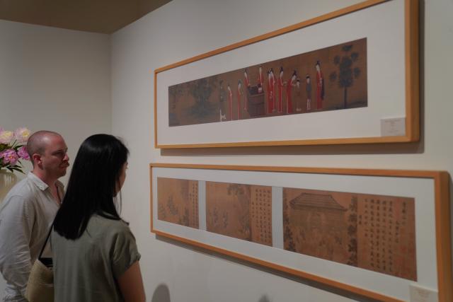 (260806) -- NEW YORK, Aug. 6, 2026 (Xinhua) -- People view ancient paintings during "The Unheard Melody: Exhibition of Music in Chinese Paintings" in New York, the United States, Aug. 5, 2026. The exhibition opened here on Wednesday. Featuring musical imagery from the art of ancient Chinese painting, it showcases a curated selection of masterpieces inspired by music from the Song Dynasty (960-1127), and invites visitors to explore the sounds and stories embedded within the artworks. (Xinhua/Zhang Fengguo)