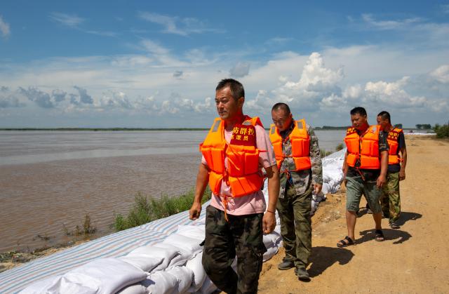 (260806) -- HARBIN, Aug. 6, 2026 (Xinhua) -- Staff members patrol the embankment along the Jiamusi section of the Songhua River in northeast China's Heilongjiang Province, Aug. 6, 2026. Flood prevention measures have been implemented across northeast China's Heilongjiang Province, which has entered its main flood season.
  China has earmarked 50 million yuan (about 7.36 million U.S. dollars) in central government funds to support post-disaster recovery in flood-hit Heilongjiang Province in the northeast, the National Development and Reform Commission (NDRC) said Tuesday. (Photo by Chen Zhiguo/Xinhua)