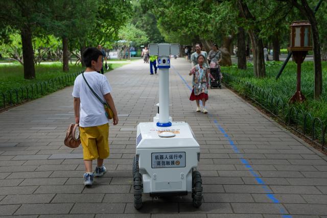 (260806) -- BEIJING, Aug. 6, 2026 (Xinhua) -- A robot patrols at the Temple of Heaven Park in Beijing, capital of China, Aug. 6, 2026.
  Fourteen municipal parks in Beijing have recently introduced a variety of new robots. These robots are now performing tasks such as cleaning, smart inspection, guided tours, water rescue, landscape maintenance, and ecological monitoring, bringing smart services into daily public life. (Xinhua/Ju Huanzong)