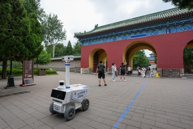 (260806) -- BEIJING, Aug. 6, 2026 (Xinhua) -- A robot patrols at the Temple of Heaven Park in Beijing, capital of China, Aug. 6, 2026.
  Fourteen municipal parks in Beijing have recently introduced a variety of new robots. These robots are now performing tasks such as cleaning, smart inspection, guided tours, water rescue, landscape maintenance, and ecological monitoring, bringing smart services into daily public life. (Xinhua/Ju Huanzong)