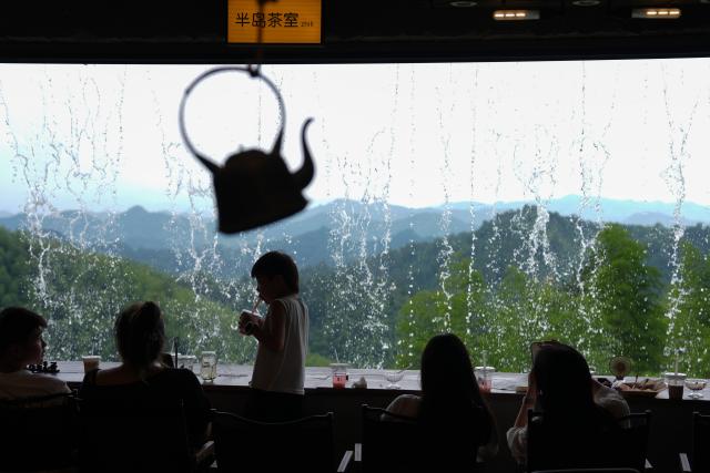 (260806) -- ANJI, Aug. 6, 2026 (Xinhua) -- Visitors enjoy leisure time at a coffee shop nestled in the mountains of Anji County, east China's Zhejiang Province, Aug. 5, 2026. During the summer vacation, Anji County leverages its cool weather and beautiful scenery, attracting numerous tourists to escape the summer heat. (Xinhua/Huang Zongzhi)