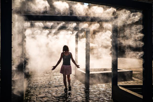 (260806) -- BUDAPEST, Aug. 6, 2026 (Xinhua) -- A woman cools off under a misting system in Budapest, Hungary, Aug. 6, 2026. Hungarian authorities on Tuesday extended the country's highest-level heat alert until midnight on Friday as forecasts indicate the ongoing heatwave will continue across the country. (Photo by David Balogh/Xinhua)