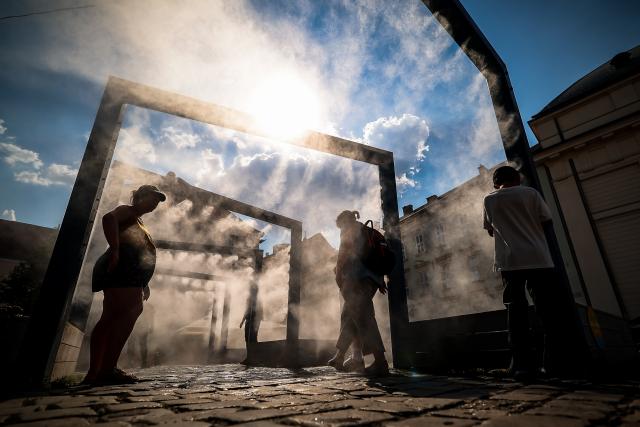 (260806) -- BUDAPEST, Aug. 6, 2026 (Xinhua) -- People cool off under a misting system in Budapest, Hungary, Aug. 6, 2026. Hungarian authorities on Tuesday extended the country's highest-level heat alert until midnight on Friday as forecasts indicate the ongoing heatwave will continue across the country. (Photo by David Balogh/Xinhua)