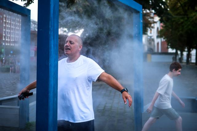 (260806) -- BUDAPEST, Aug. 6, 2026 (Xinhua) -- People cool off under a misting system in Budapest, Hungary, Aug. 6, 2026. Hungarian authorities on Tuesday extended the country's highest-level heat alert until midnight on Friday as forecasts indicate the ongoing heatwave will continue across the country. (Photo by David Balogh/Xinhua)