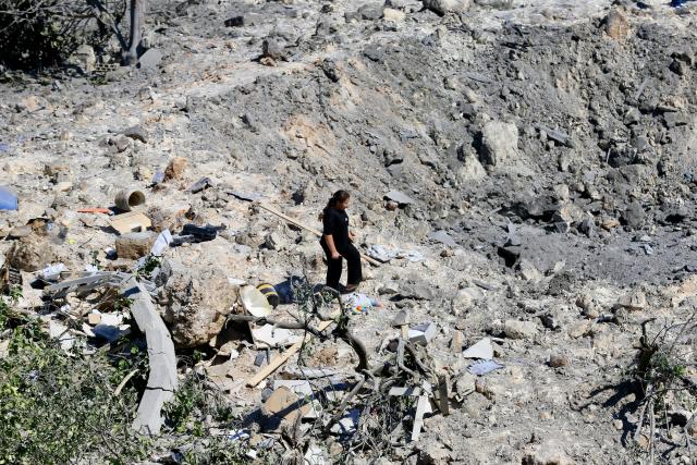 (260806) -- BURJ AL-SHEMALI, Aug. 6, 2026 (Xinhua) -- Photo taken on Aug. 6, 2026, shows a resident standing beside a large crater at the site of a house destroyed in an Israeli airstrike before dawn in Burj al-Shemali, near the southern Lebanese city of Tyre. Four people were injured early Thursday in Israeli airstrikes targeting the town of Burj al-Shemali, near the southern city of Tyre, according to Lebanon's state-run National News Agency. (Photo by Ali Hashisho/Xinhua)