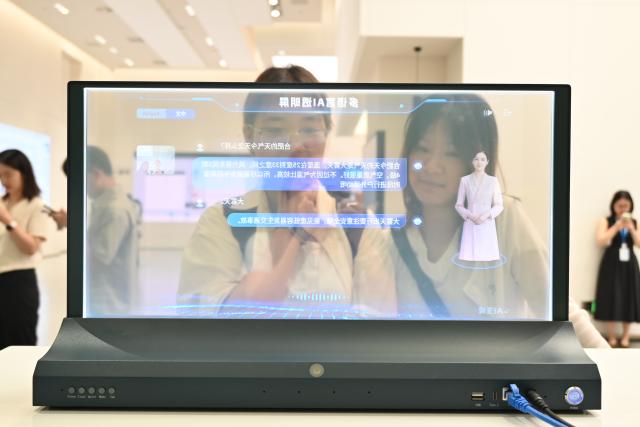 (260807) -- BEIJING, Aug. 7, 2026 (Xinhua) -- Visitors try out a multilingual AI transparent screen capable of real-time language recognition and translation at an experience center of the iFLYTEK AI Headquarters Campus in Hefei, east China's Anhui Province, Aug. 6, 2026. (Photo by Lin Qiujin/Xinhua)